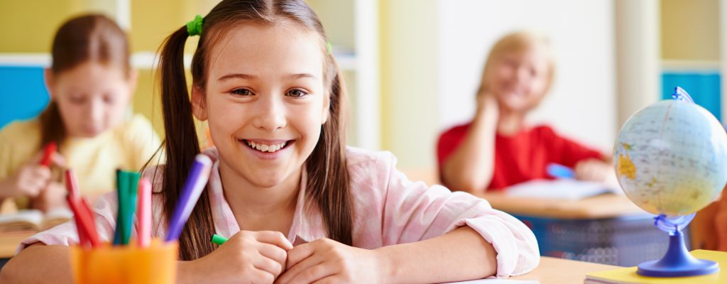 Portrait of lovely girl looking at camera at lesson of drawing